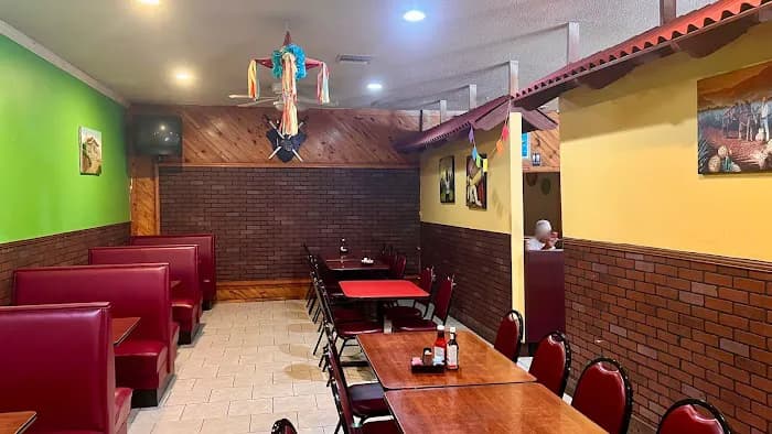 Coco Loco dining room with red booths, colorful decor, and piñata overhead